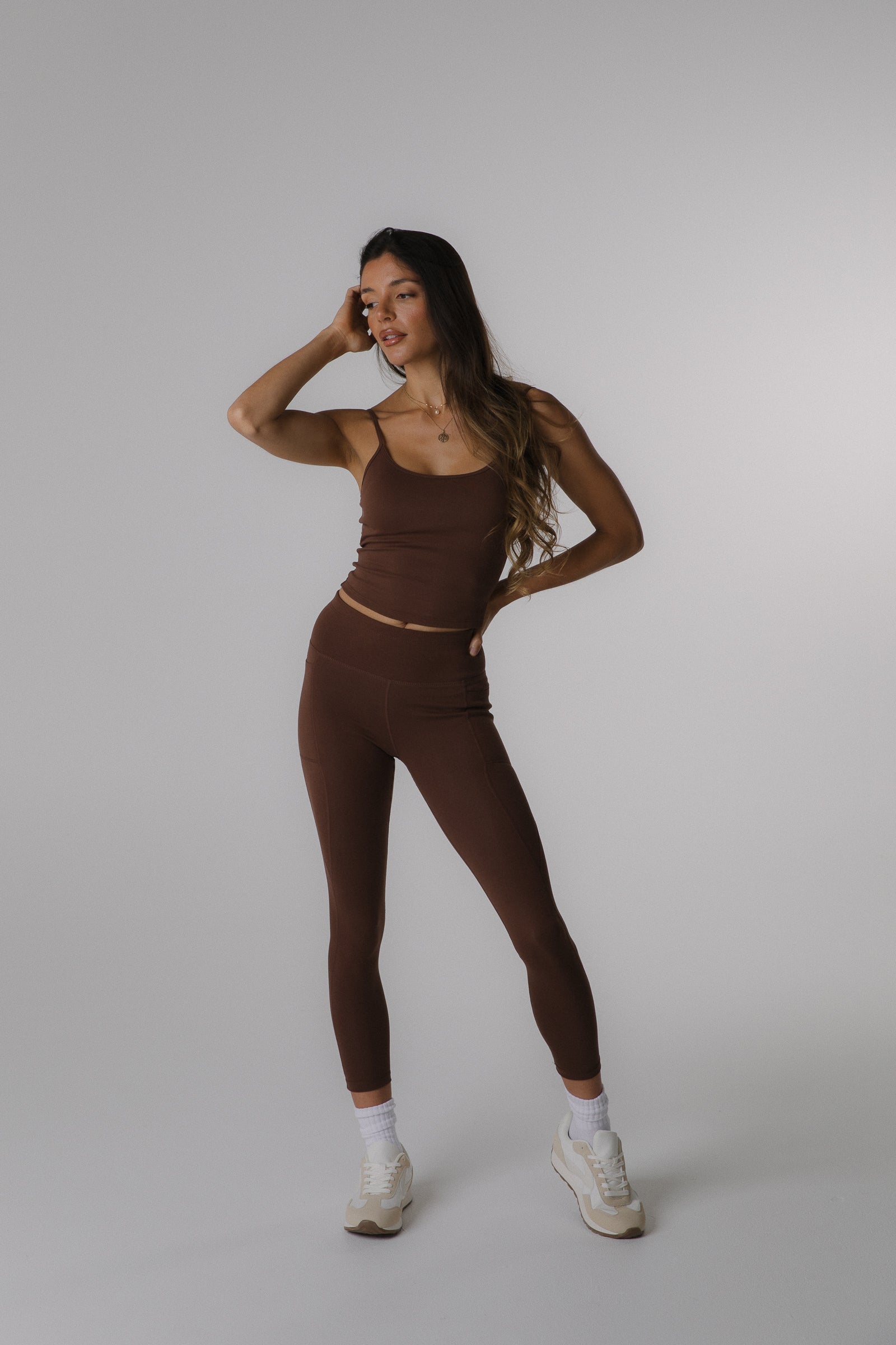 Woman wearing a brown cotton Cami top and cotton leggings.